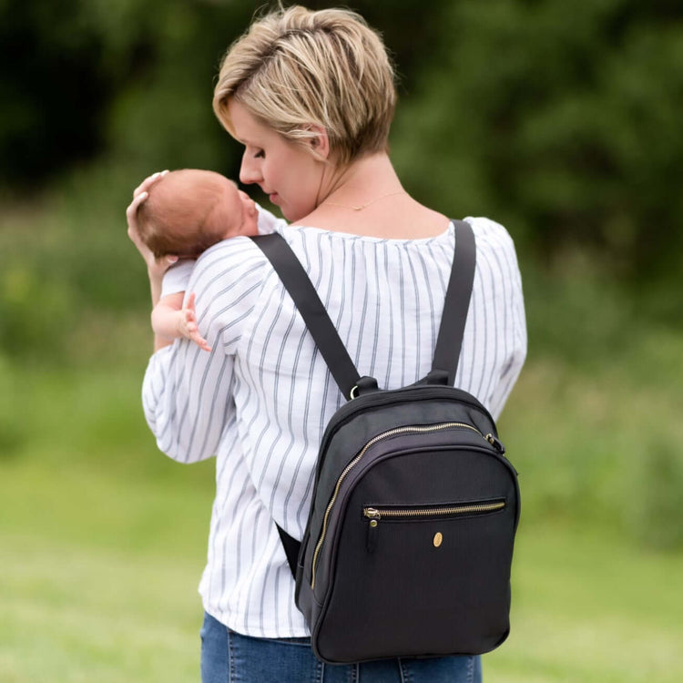 mom with newborn baby wearing a diaper backpack bag