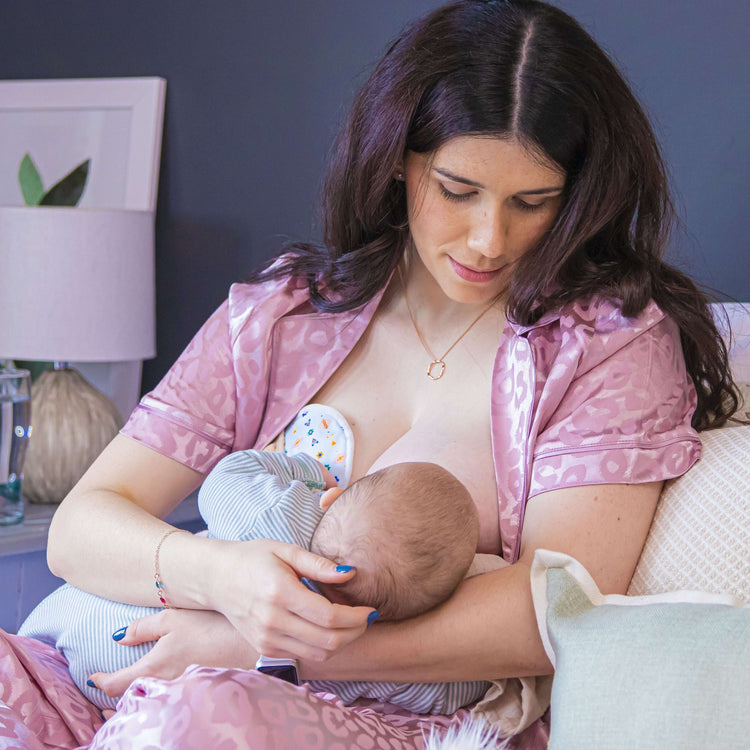 mom nursing her baby while using soft bamboo reusable nursing breast pads