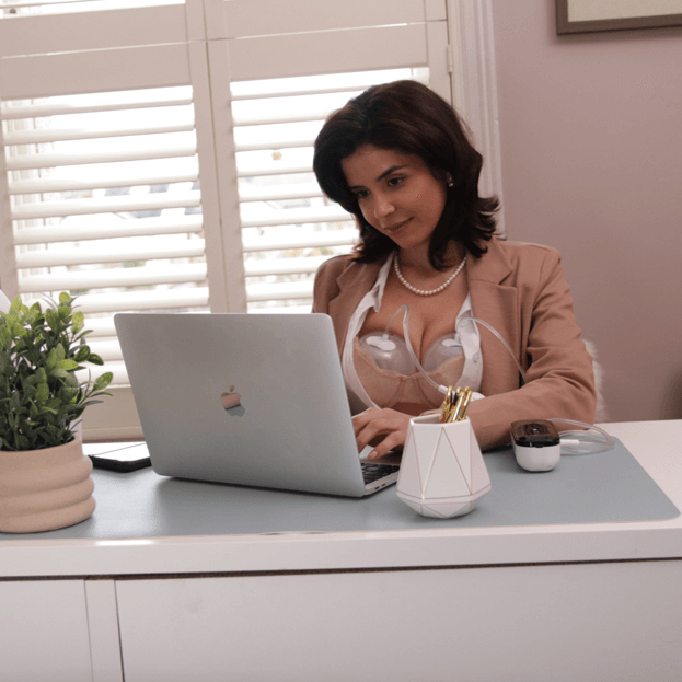 mom pumping with the pump-a-collect breastmilk collection cups while working