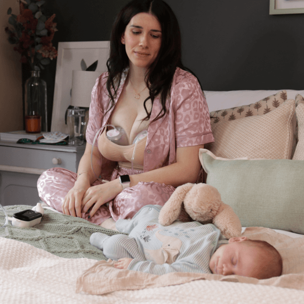 mom pumping with the pump-a-collect breastmilk collection cups while looking after her son