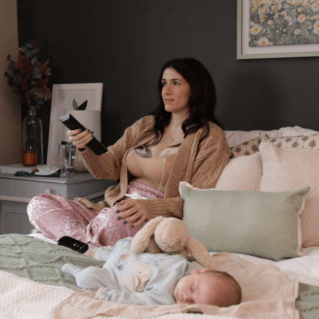 mom pumping with the pump-a-collect breastmilk collection cups while watching television