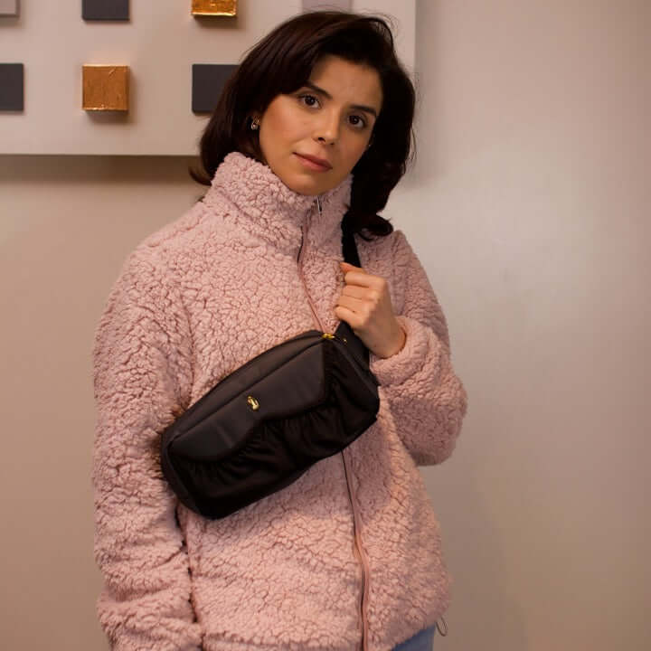 content mom carrying the pump-a-porter mini wearable breast pump bag as sling bag
