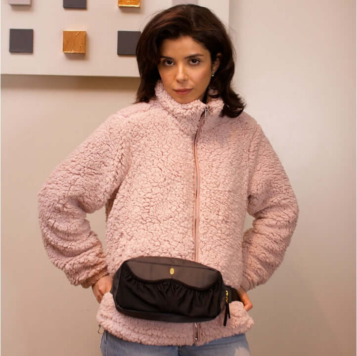 mom wearing the pump-a-porter mini wearable pump bag as a belt bag with two spacious front pockets for pumping essentials