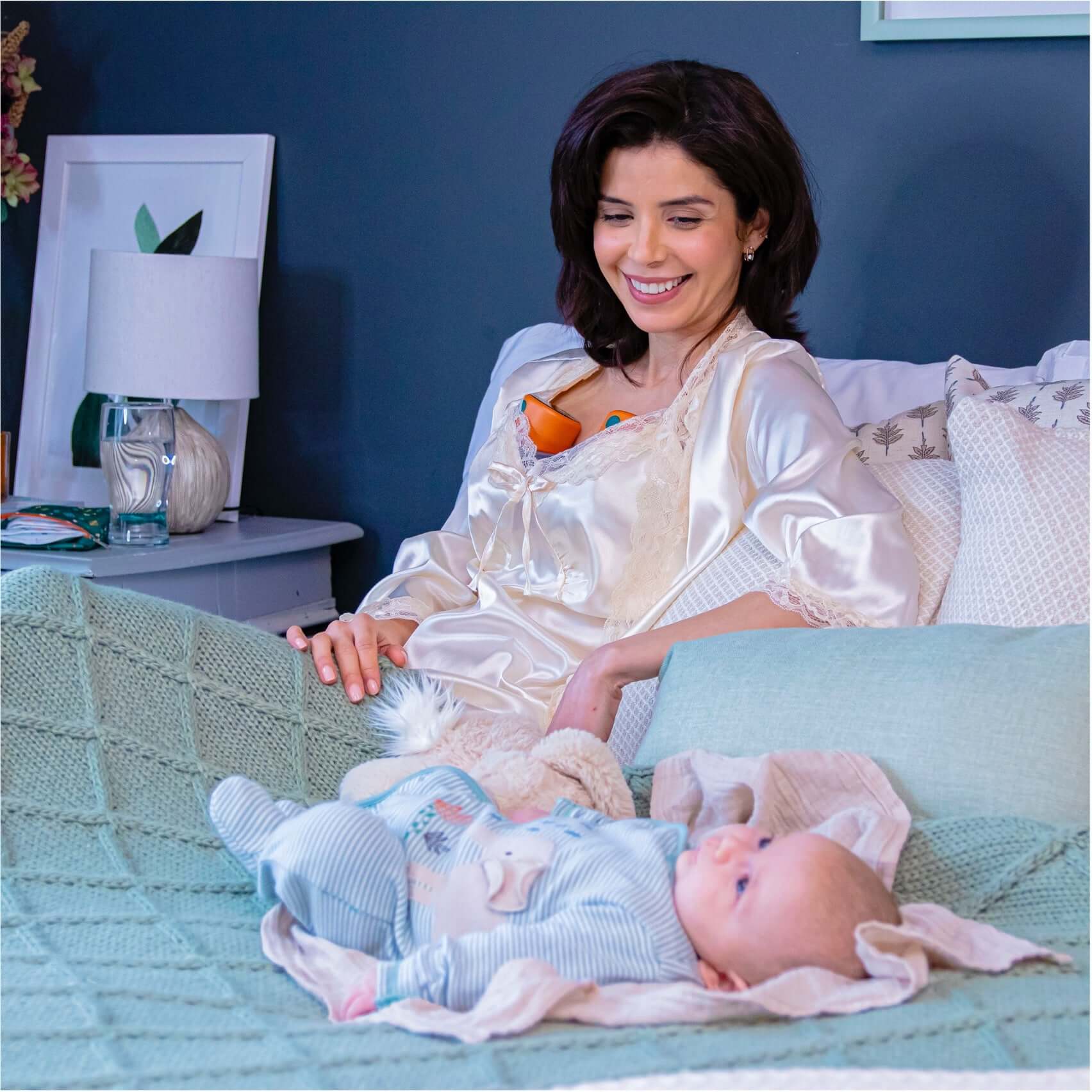 mom relaxingly pumping with pump-a-wear wearable pump while looking after her baby