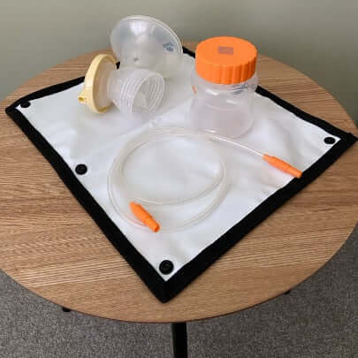 Image of breast pump parts placed on the robin detachable waterproof mat